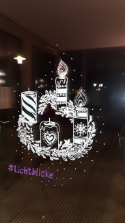 Ein Adventskranz mit brennenden Kerzen ist auf eine Fensterscheibe gemalt.
